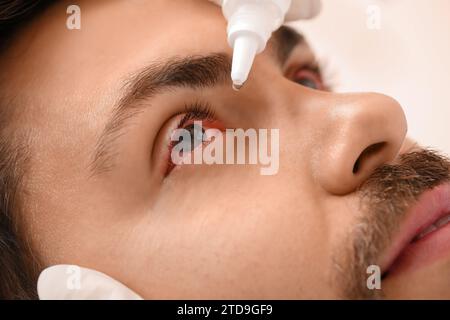 Ophthalmologist putting drops in young man's eyes, closeup Stock Photo