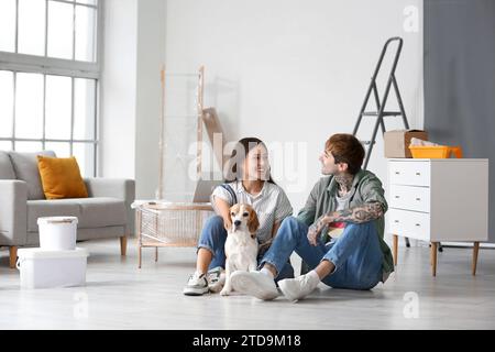 Young couple with Beagle dog sitting during repair in their new house Stock Photo