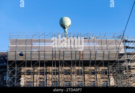 Amsterdam The Netherlands 17th December 2023 The rear of the Palace on the Dam wrapped in scaffolding for renovations. From the top the statue of Atlas holding up the world looks as if he is need of support. werkzaamheden, steigers,paleis, globe, standbeeld, Stock Photo
