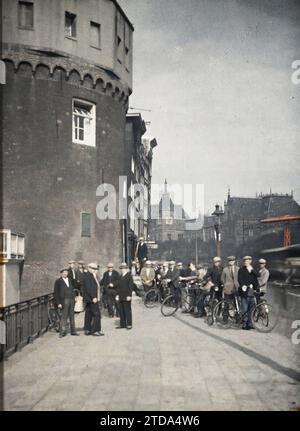 Amsterdam, Netherlands A group on the Prins Hendrik Kade, near the Schreierstoren, with the central station in the background, Transport, Daily life, Housing, Architecture, Art, Cycle transport, Tower, Crowd, Quay, Scene of street, Fortified architecture, Street, District, Middle Ages, Holland, Amsterdam, North East District, Amsterdam, 26/08/1929 - 26/08/1929, Passet, Stéphane, photographer, 1929 - Pays-Bas - Stéphane Passet - (17-31 August), Autochrome, photo, Glass, Autochrome, photo, Positive, Vertical, Size 9 x 12 cm Stock Photo