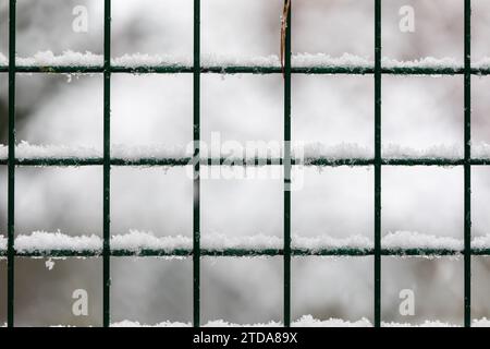 Captivating Winter Scene: Fresh Snow on Metal Fence in Blurry Grey Background Stock Photo