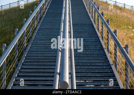 Elevated Pathways: Long Metal Staircases Ascending and Descending a Hillside for Seamless Access Stock Photo