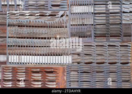 Perforated iron rusty plates with perforations in shape of various knives Stock Photo