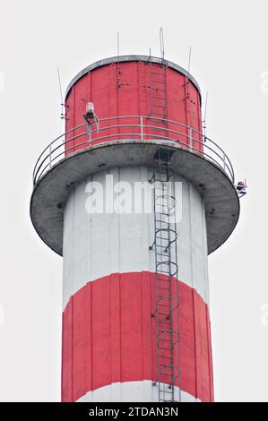 High, old, red and white smokestack in industrial area in Roznov pod Radhostem, Czech republic. Stock Photo