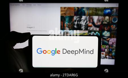 Person holding cellphone with logo of artificial intelligence company Google DeepMind in front of business webpage. Focus on phone display. Stock Photo
