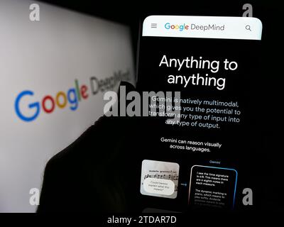 Person holding cellphone with webpage of artificial intelligence company Google DeepMind in front of logo. Focus on center of phone display. Stock Photo