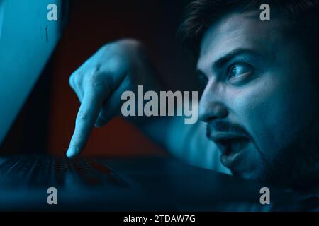 A man with a crazy, gambling expression on his face presses enter. Stock Photo