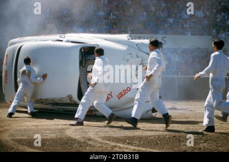 SACRAMENTO, CA - AUGUST, 1958: A group of men run to help the driver after crashing during a car show at the Sacramento State Fair circa August, 1958 in Sacramento, California. (Photo by Hy Peskin) Stock Photo