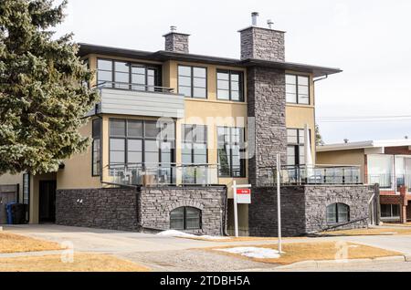 Real estate sign in front of a semi-detached house on sale on cloudy winter day Stock Photo