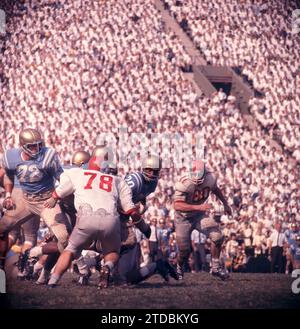 LOS ANGELES, CA - OCTOBER 6:  Ezell Singleton #20 of the UCLA Bruins runs with the ball as Daniel Porretta #78 and Robert Middleton #80 of the Ohio State Buckeyes look to make the tackle during an NCAA game on October 6, 1962 at the Los Angeles Memorial Coliseum in Los Angeles, California.  (Photo by Hy Peskin) *** Local Caption *** Ezell Singleton;Daniel Porretta;Robert Middleton Stock Photo