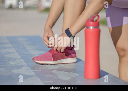 Detail of a girl's feet tying the laces of her sneaker. Stock Photo