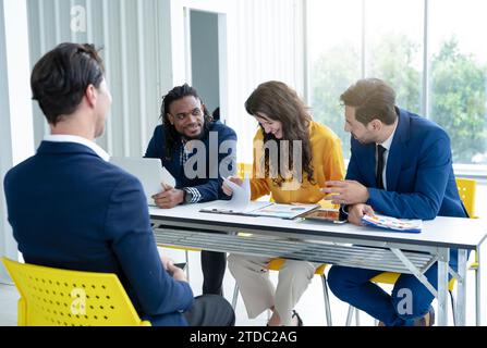 Job interview concept. Diverse hr team doing job interview with a man in business office. Human resources team interviewing a potential job candidate. Stock Photo