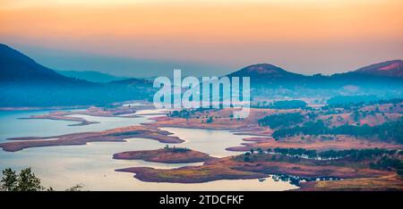 An early morning shot of the Umiam lake, also known as Barapani lake, during the dry winter season. Water level at its lowest. Stock Photo