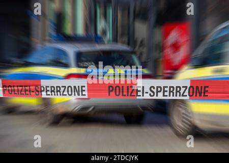 Symbolbild: Polizeiabsperrung mit Polizeifahrzeugen im Hintergrund