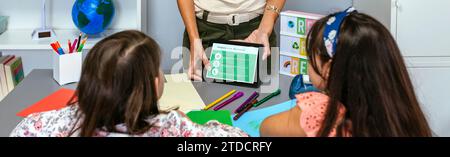 Teacher showing tablet with tips to be more ecological for students in environmental classroom Stock Photo