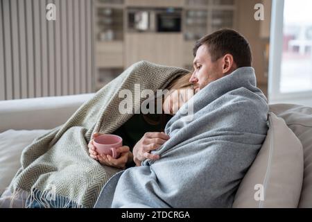 Caring husband supporting unhealthy woman with high temperature, headache, leaning on man shoulder Stock Photo