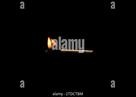 Lit and falling match on a black background. Stock Photo