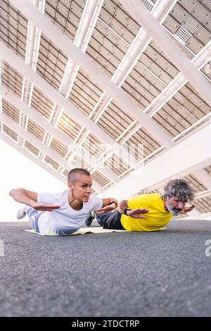 senior man doing planks with his personal trainer Stock Photo