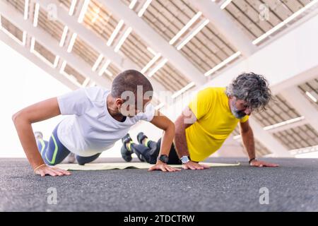 senior man doing push ups with personal trainer Stock Photo