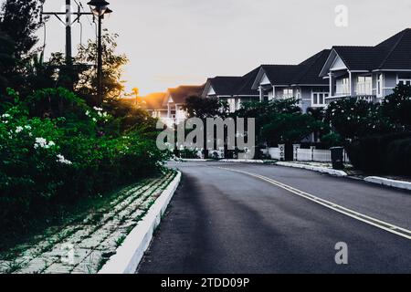 Modern cottages row road sidewalk two story buildings residential villas village New Estate Reflection dawn Sun in windows  Stock Photo
