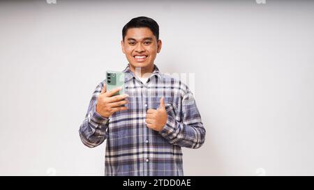 Adult Asian man showing excited expression when holding a mobile phone Stock Photo