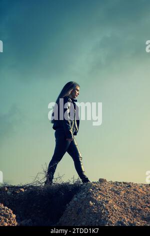 Woman in leather walking outdoors Stock Photo