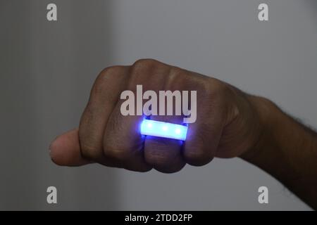 LED light ring of blue color. Wearing a glowing light ring on the finger Stock Photo