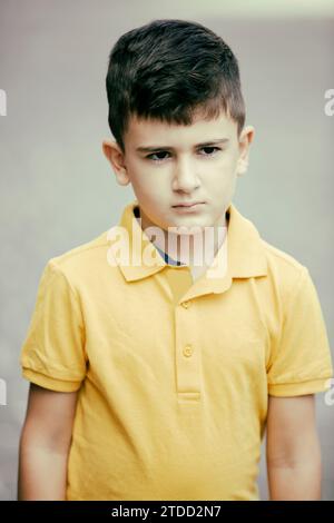 8 years old boy standing outdoors looking away Stock Photo
