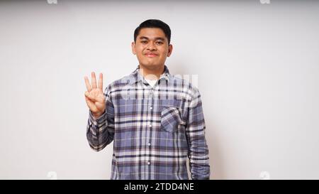 Young Asian man showing happy face expression while giving three fingers sign Stock Photo