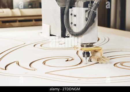 Numerically controlled woodworking machine cuts rounded complex lines on the canvas. Computer numerical control. CNC. Stock Photo