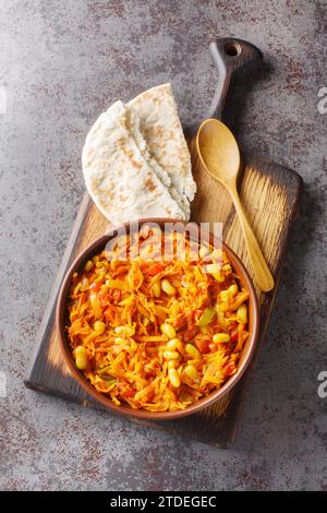 Chakalaka is a South African vegetable relish usually spicy, that is traditionally served with bread closeup on the bowl on the table. Vertical top vi Stock Photo