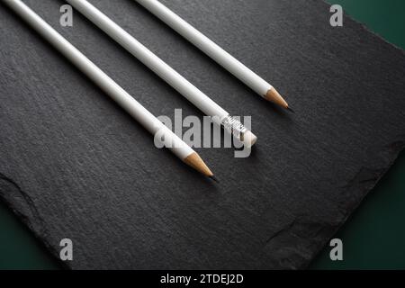 Three blank white pencils on stone board background. Stock Photo