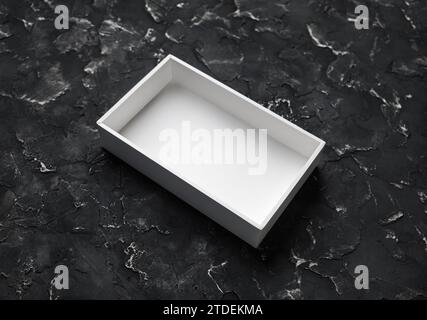 Blank white opened box on black plaster background. Stock Photo