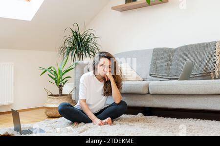 Sad woman sitting on floor at home. Mental illness. Stock Photo