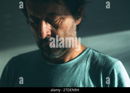 Midlife crisis of middle aged man. Closeup portrait of man in 40s in a depressed state of mind, sad and hopeless. Selective focus. Stock Photo