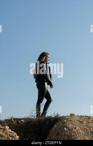 Woman in leather walking on the hill Stock Photo