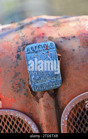 A badge on a rusty derelict Nuffield Universal tractor abandoned on a farm, England, UK Stock Photo