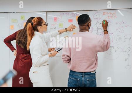 Young colleagues collaborate in a modern office, brainstorming and planning business growth. Stock Photo