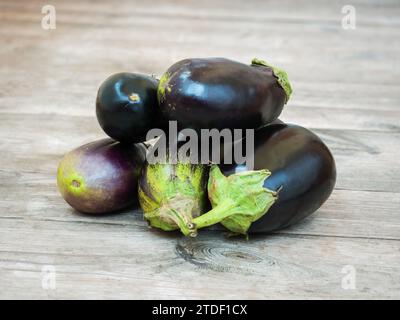 Fresh eggplants on an unpainted wooden rustic table Stock Photo