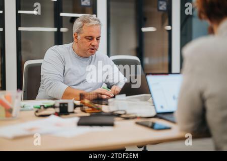 Businesspeople collaborate in an office, discussing strategies, reviewing stats. Focused on achieving financial growth and profit. Stock Photo