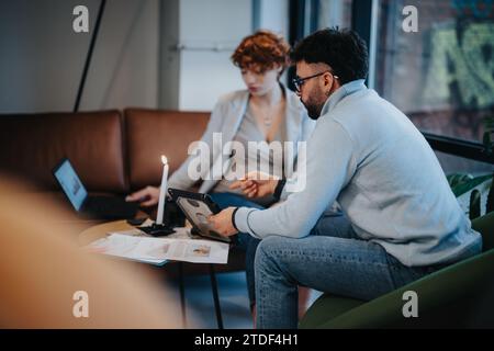 Young executives collaborate in a modern office, discussing strategies and planning tasks together towards business growth. Stock Photo