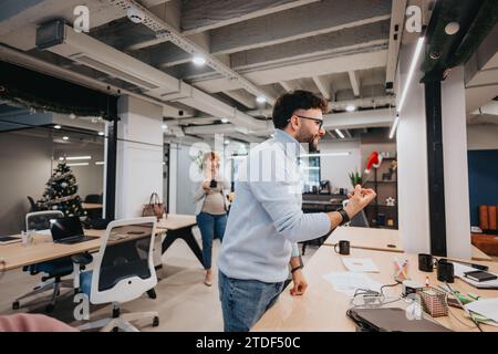 Young business professionals collaborating, discussing growth, analyzing data, and planning tasks in a pleasant and creative atmosphere. Stock Photo
