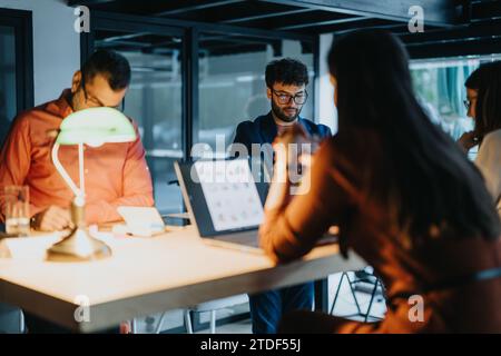 Different aged business team analyzing reports, discussing solutions, and driving profit growth through data analytics and market research. Stock Photo