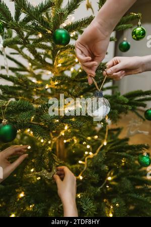 Women hangs a balls on a New Year tree. Stock Photo