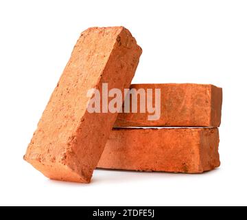 Cracked old red or orange bricks in stack are isolated on white background with clipping path. Stock Photo