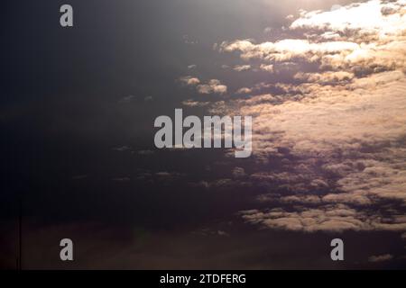Fluffy gray clouds floating scattered across the sky at sunrise Stock Photo