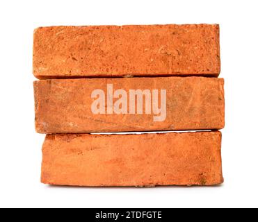 Cracked old red or orange bricks in stack are isolated on white background with clipping path. Stock Photo