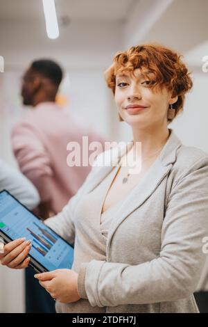 A businesswoman collaborates with a diverse group in an office, analyzing data and strategizing for success. Stock Photo