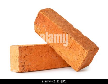 Cracked old red or orange bricks in stack or cross shape are isolated on white background with clipping path. Stock Photo