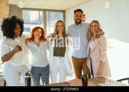 Diverse business team smiling while standing together in the office. Business concept. Stock Photo